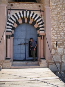 Student emerging from traditional Tunisian door within a door
